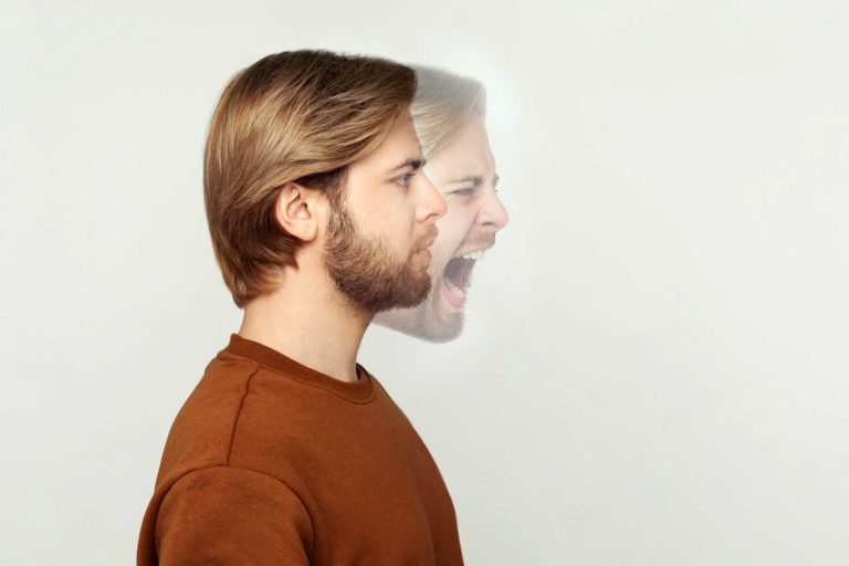 a man with co-occurring disorders stands calmly but his inner self is depicted as being enraged