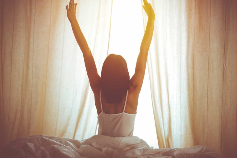 woman waking up and stretching after going to rehab
