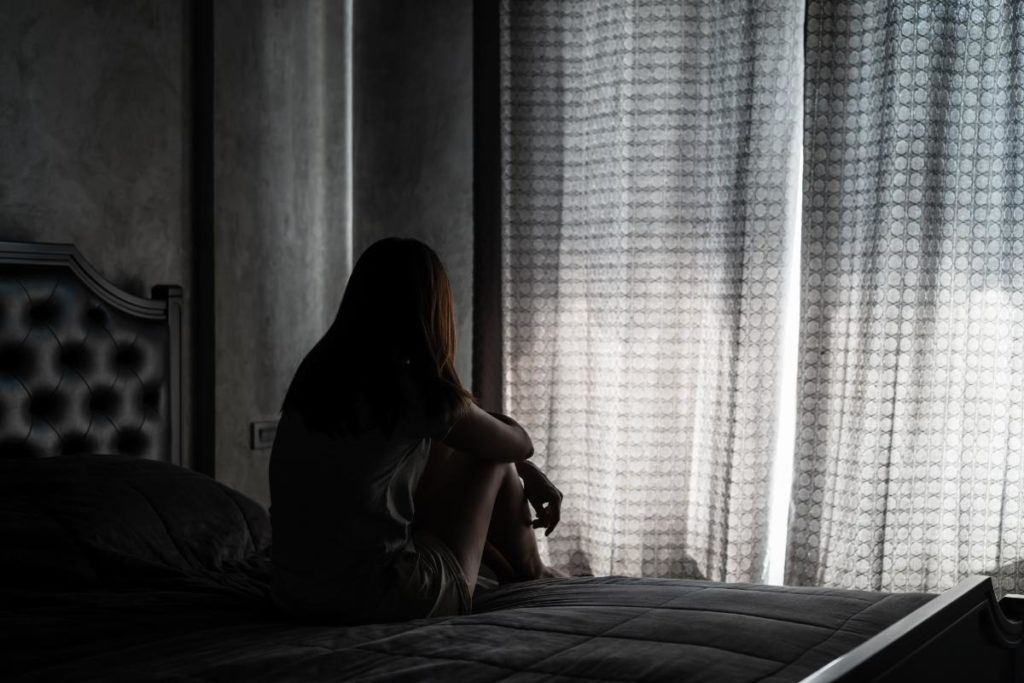 Woman by window learning about the dangers of meth abuse