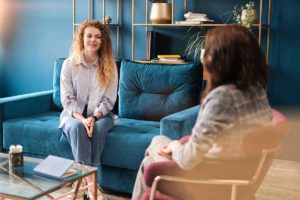 woman on couch learning about the benefits of trauma therapy