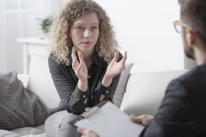 woman with curly hair discusses past trauma therapy