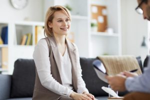 blond woman on couch learns what an employee assistance program is