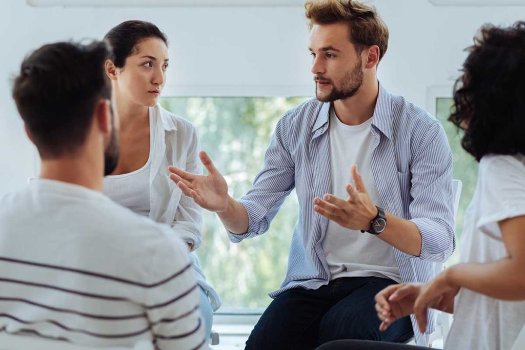 man explains to others what group therapy is