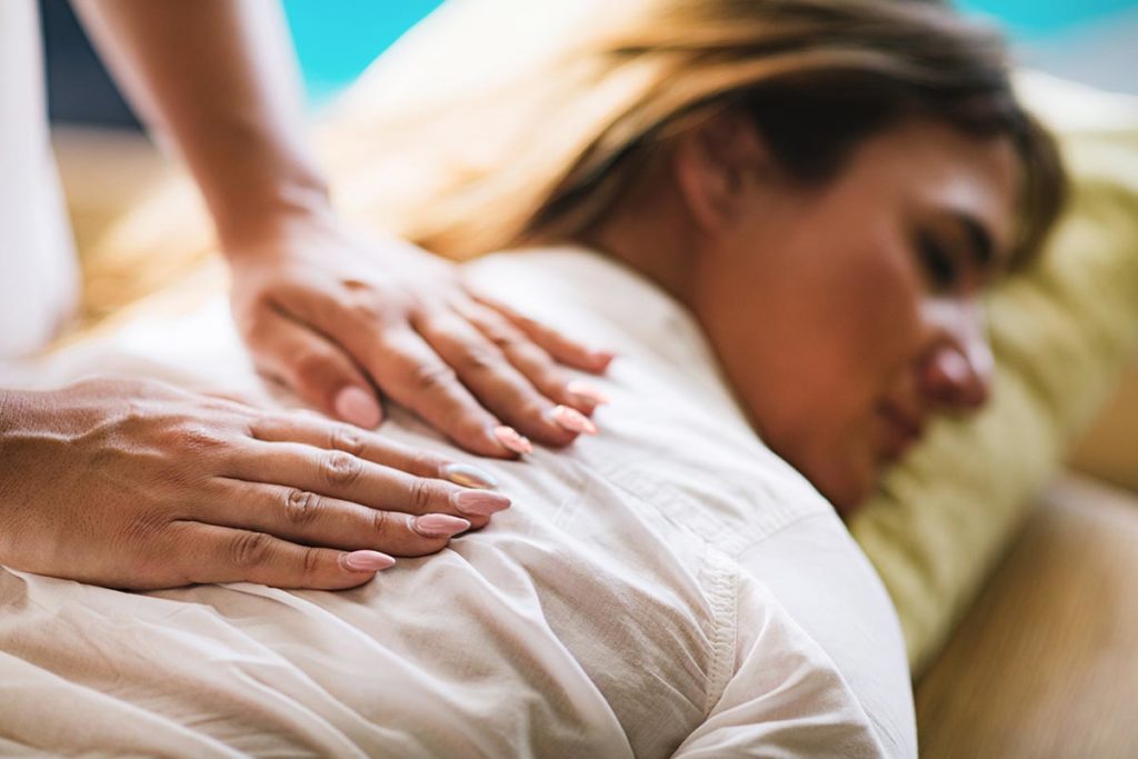 woman on massage table learning what is holistic therapy