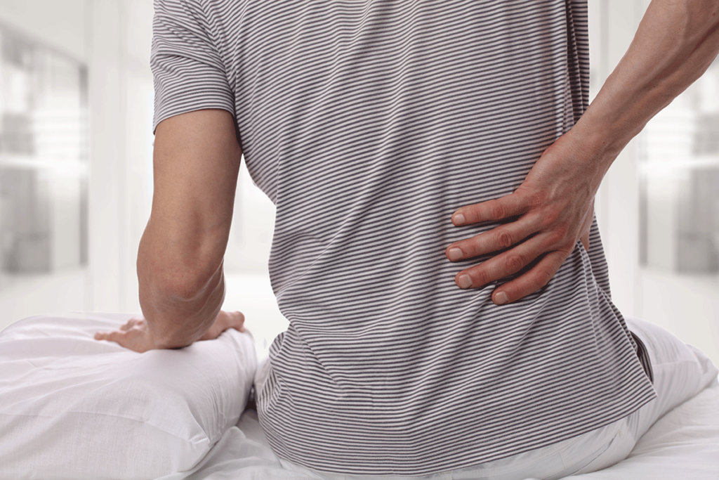 a man deals with his usual chronic back pain when waking up in the morning