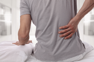 a man deals with his usual chronic back pain when waking up in the morning