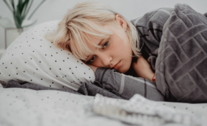 a young woman struggles to get out of bed due to her ptsd