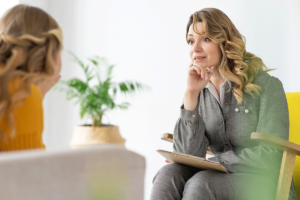 a therapist listens to a client in person centered therapy for addiction recovery