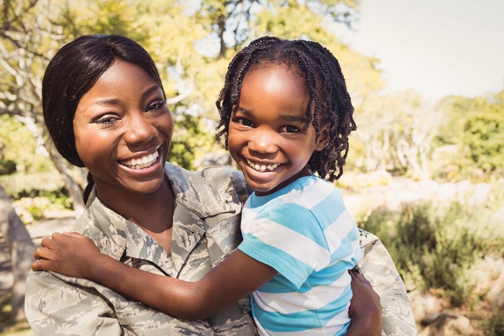 Veteran Mother holding her daughter happy to be sober and healthy after using her TRICARE insurance for addiction treatment