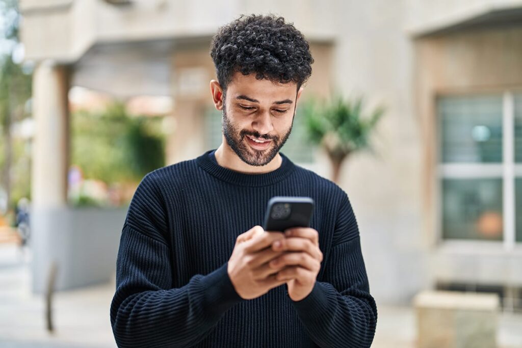 Man on his phone looking up his Tricare insurance benefits for addiction treatment