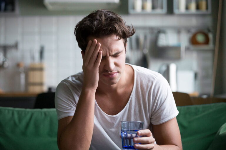 a man with a headache from his alcohol withdraw