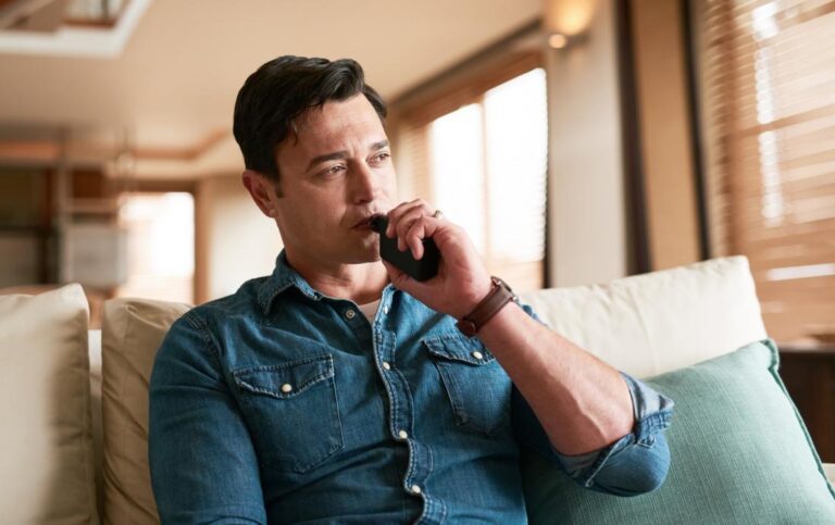 A man vaping on a couch with anxiety