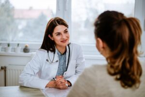 A female doctor speaking with a patient at a desk
