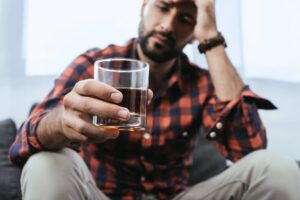 Man contemplates drinking another glass of liquor