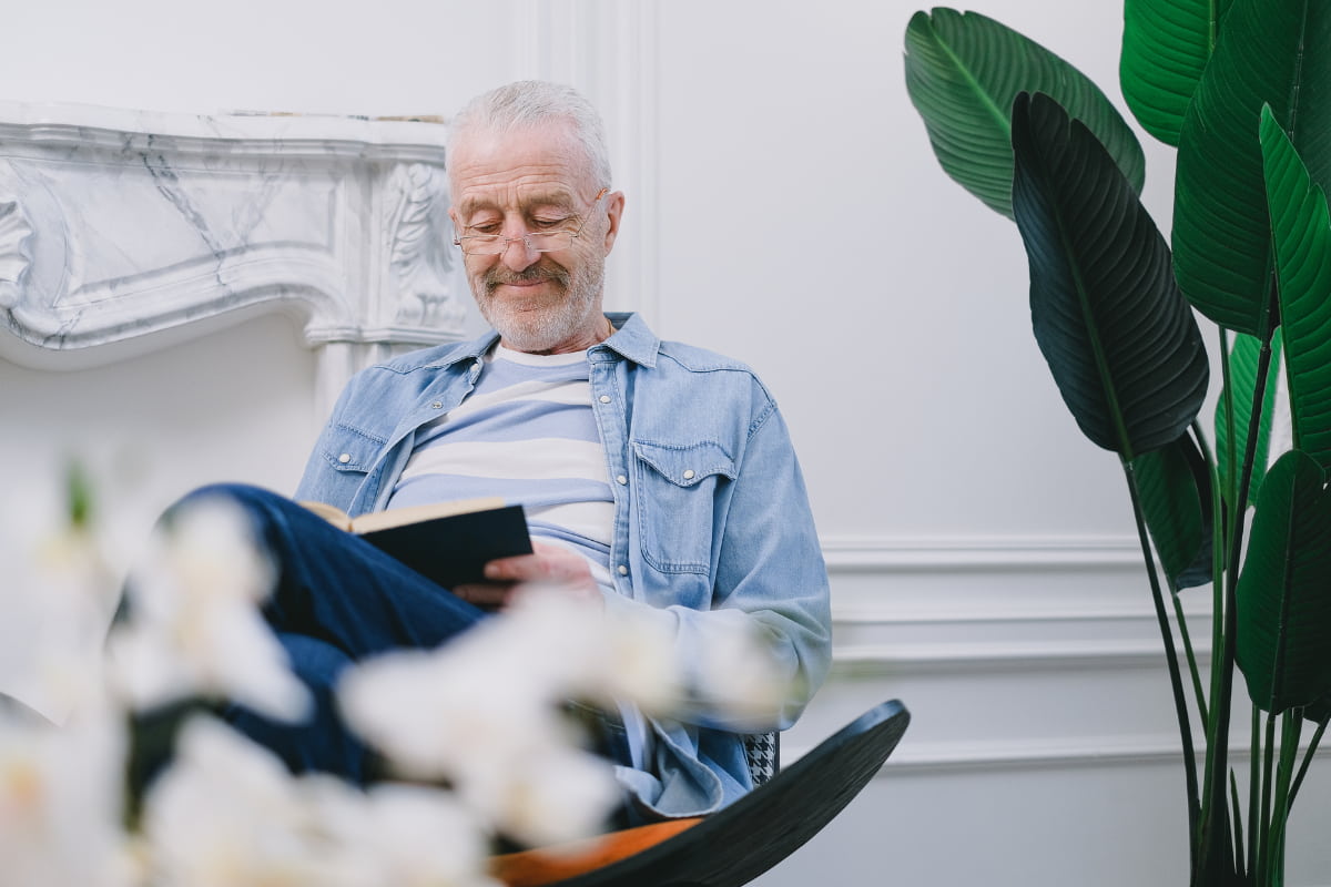 A happy elderly man reading a book