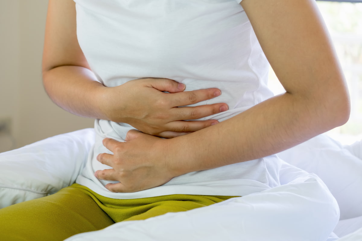 Woman with stomach ache due to drinking on antibiotics