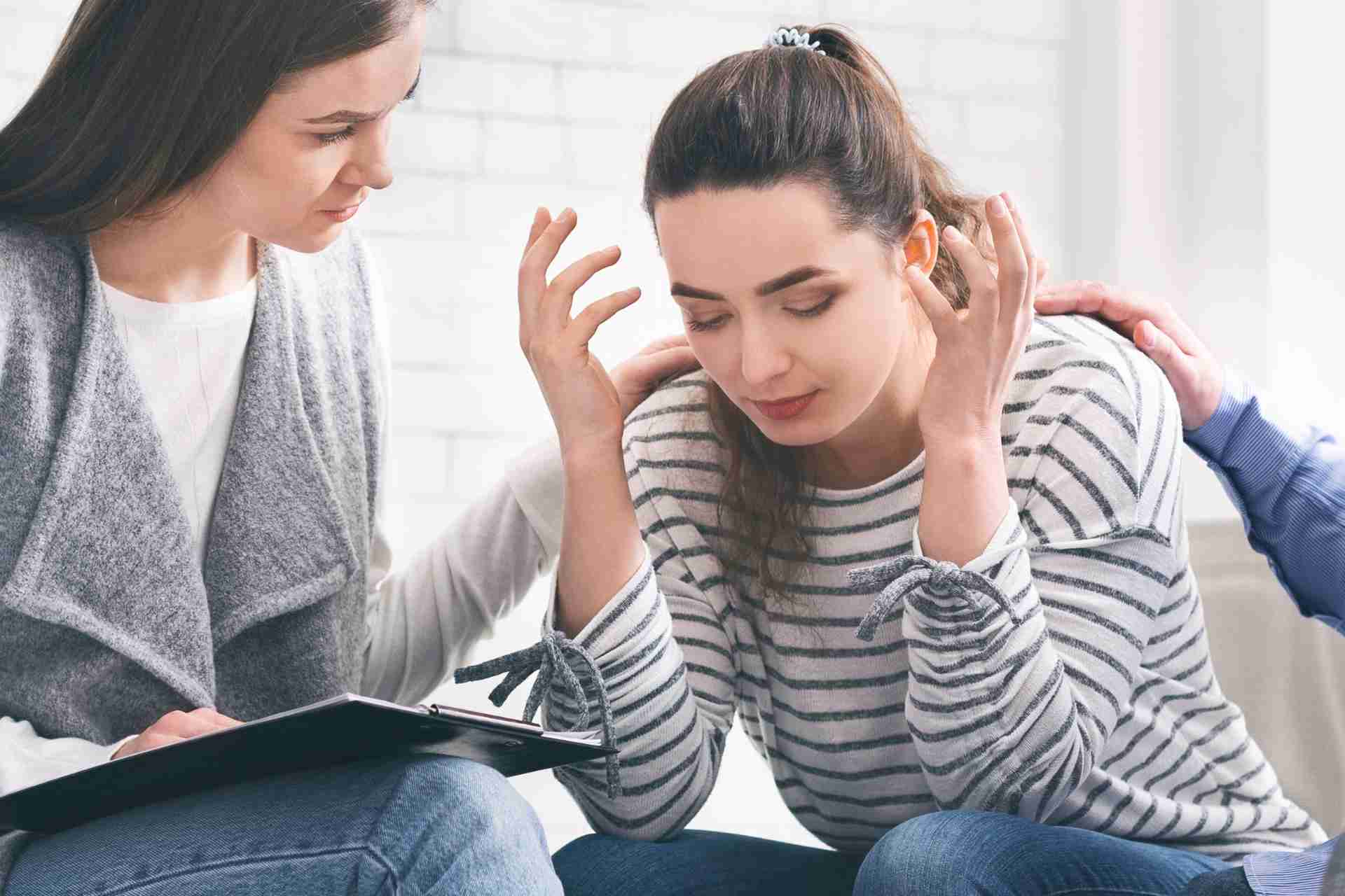 Family supporting distressed woman during addiction intervention.
