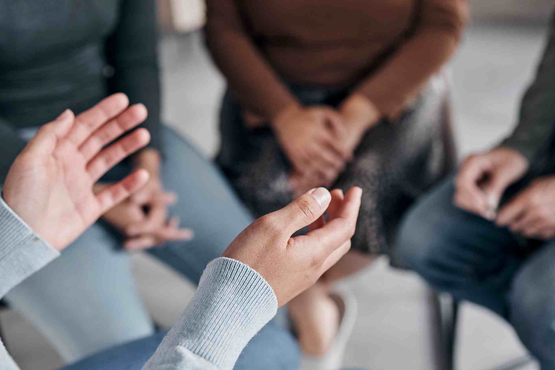 People participating in a group therapy discussion for addiction recovery