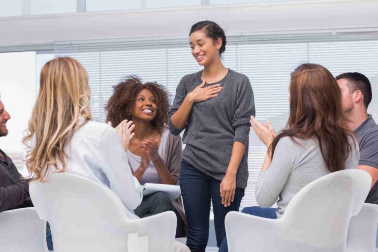 Woman speaking during a supportive group therapy session for addiction recovery