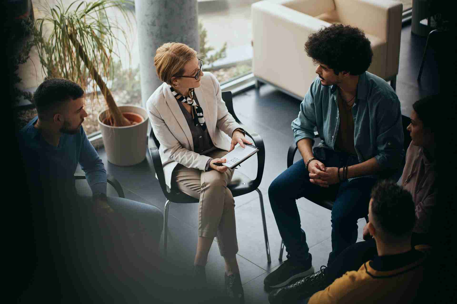 Addiction counselor leading a group therapy session for individuals in recovery