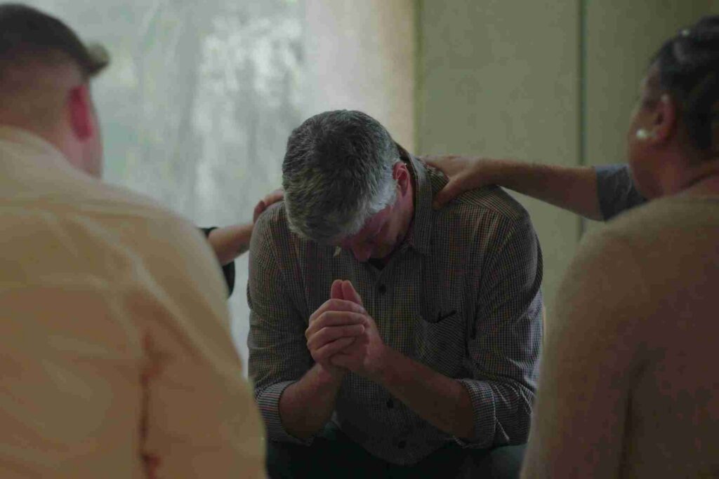 Individual receiving support from peers during an alcohol addiction recovery group session