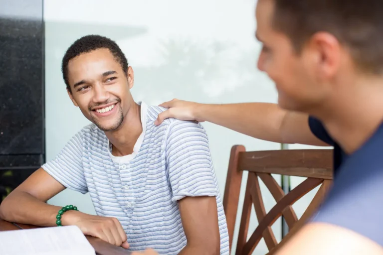a young man enters recovery thanks to professional heroin addiction treatment and is congratulated by a friend