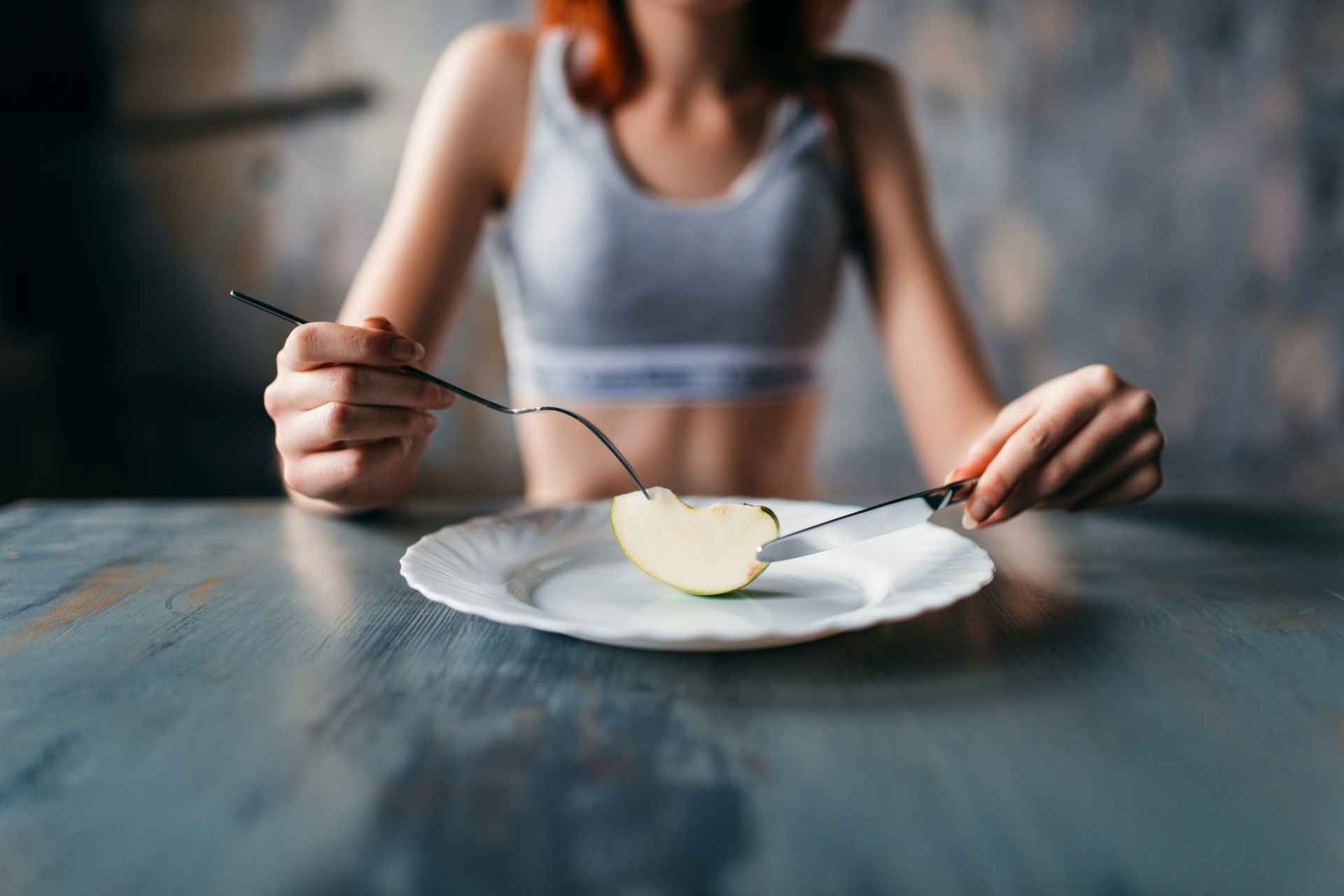 Woman sitting with a very small portion of food on her plate