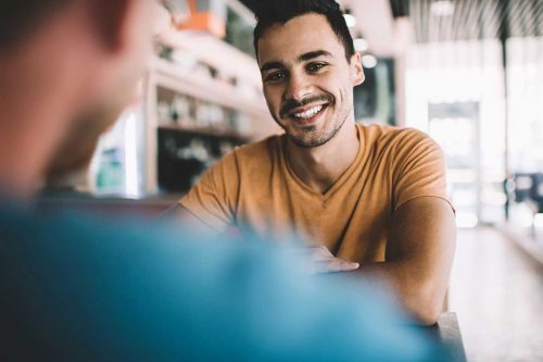 Addiction Therapy Program Man Smiling at Table